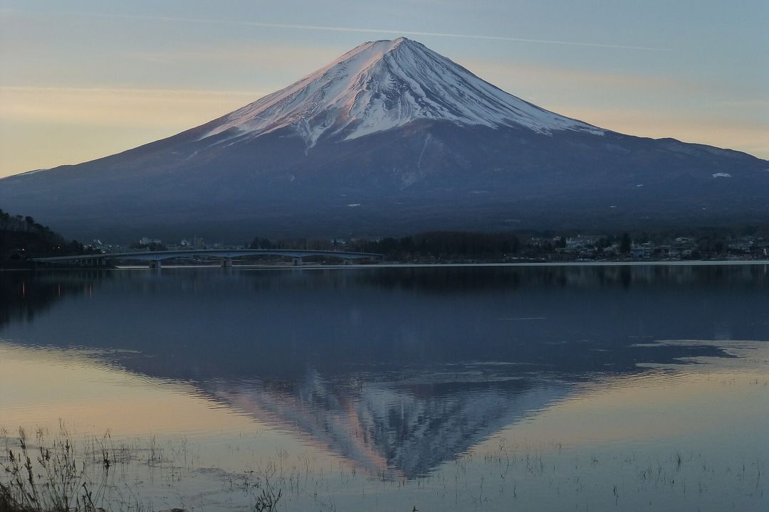 Mount Fuji reflected in the still water of Lake Kawaguchi at first light