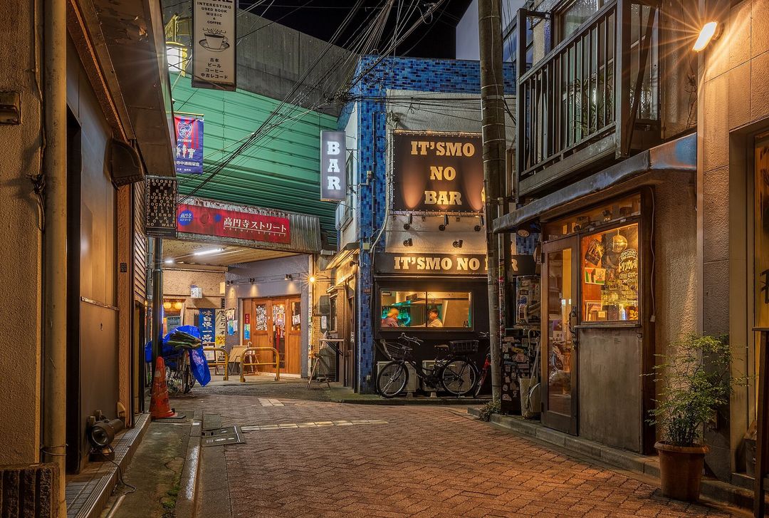 A narrow Tokyo backstreet after dark, lit by hanging shop lanterns